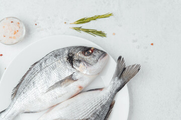 Raw dorado fish with tomatoes lemon and spices on white background