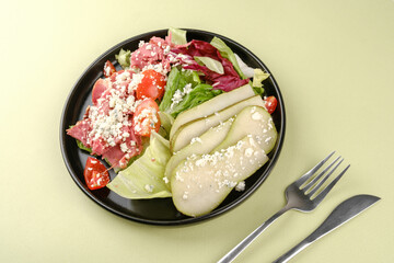 Top view of pear and blue cheese salad on pastel background for healthy eating or diet concept