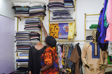 Naklejka premium A beautiful African female fashion designer working in her studio