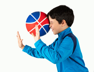 Boy with blue track suit playing sport being hit by a  basket ball with force in the face when he...