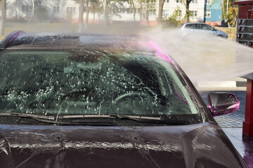 A modern car is washed at a contactless car wash.
