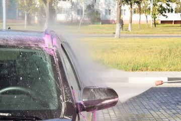 A modern car is washed at a contactless car wash.
