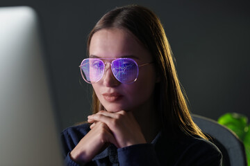 Naklejka premium Young woman wearing glasses with reflection working with computer on grey background