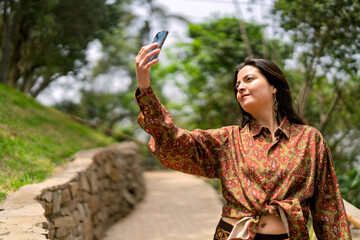 Young woman taking selfie enjoying nature in park