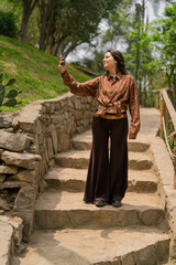 Young woman taking selfie on nature park stairs