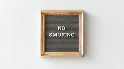 Gold framed sign with the words no smoking hanging on a light gray wall