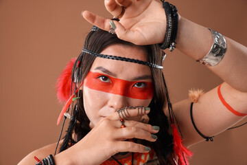 Shaman woman with face painting on brown background