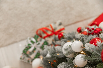Red and white Christmas balls hanging on the Christmas tree. Close-up, space for text. Postcard