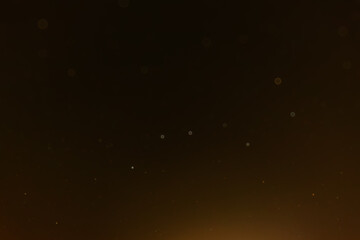 Golden night sky with softly glowing stars and bokeh lights, creating a dreamy and warm celestial atmosphere.