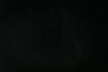 A breathtaking view of the star-filled night sky, showcasing countless stars and a faint band of the Milky Way stretching across the darkness.