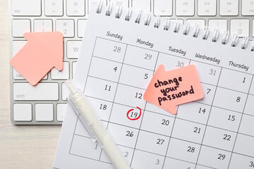 Note with phrase Change Your Password, calendar, keyboard and pen on light wooden table, flat lay