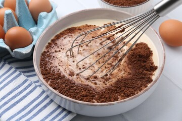 Adding cocoa powder into bowl with dough at white tiled table, closeup
