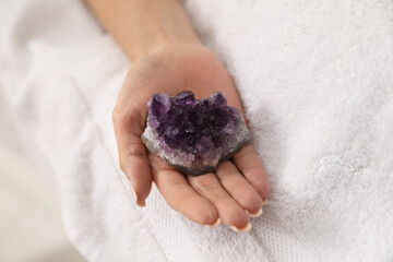 Woman undergoing crystal therapy to heal or restore her aura on couch, closeup