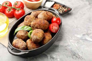 Tasty meat patties served on grey textured table, closeup