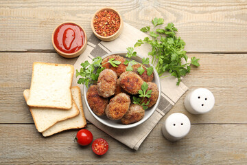 Tasty meat patties served on wooden table, flat lay