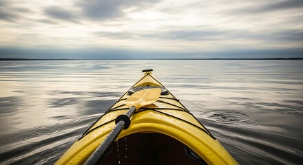 Kayaking serene lake with cloudy sky.