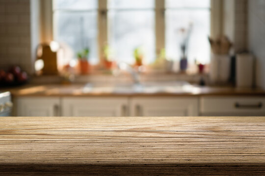 Natural wooden countertop and blurred background of a kitchen on morning hours