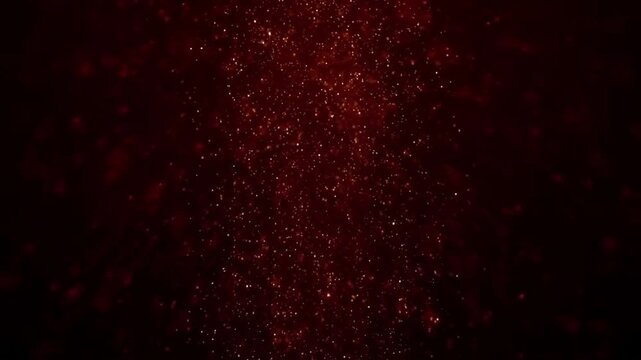 Falling glowing red dust particles floating gently on dark background