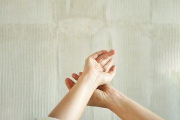 Close-up of female caucasian hands with neutral background, expressive gesture, soft light.