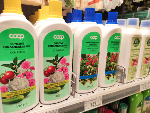 Gualdo Tadino, Italy - October 21, 2025: Coop brand plant fertilizer bottles displayed on a supermarket shelf, showcasing vibrant floral designs and product information for gardening enthusiasts