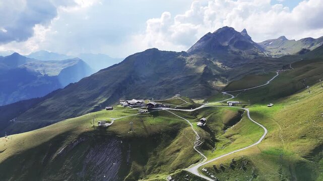 Atemberaubender Drohnenflug &uuml;ber Grindelwald First in den Schweizer Alpen mit Blick auf majest&auml;tische Berge, gr&uuml;ne Alpwiesen und klare Bergluft.