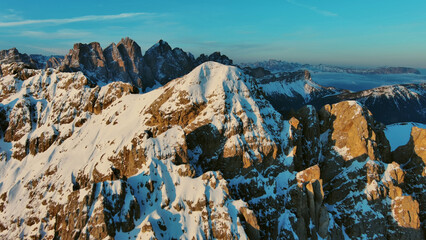 Rocky snow mountains at sunrise aerial