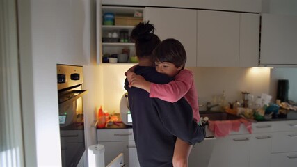 Mother holding young child in cozy kitchen, child resting quietly on her shoulder with affectionate gaze, capturing tenderness, care, and the warmth of everyday family life