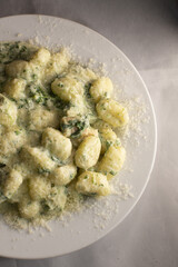 A delicious plate of gnocchi served with a rich and creamy sauce along with freshly grated cheese on top