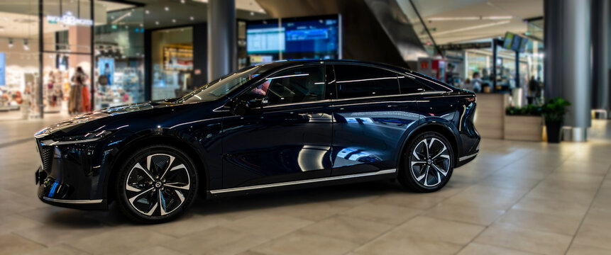 Mazda 6e electric car on display inside Centro Comercial Vialia Estaci&oacute;n de Vigo, Galicia, Spain, highlighting modern EV design in a retail setting.