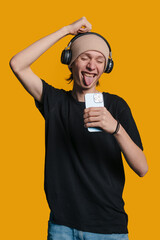 A Joyful Young Man Who is Happily Enjoying Listening to Music while Wearing His Headphones