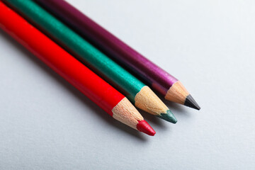 Fototapeta premium Colorful eye pencils on light background, closeup