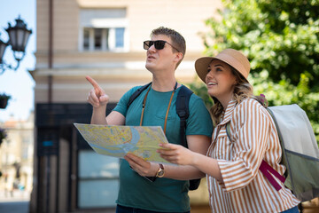 Naklejka premium Couple exploring city street pointing enjoying travel