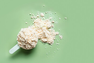 Scoop of whey protein powder on green