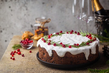Traditional Christmas cake with fruits, nuts and white glaze with Christmas decorations