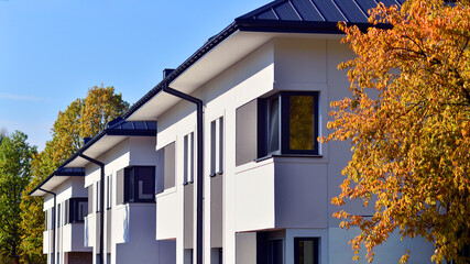Harmony with nature, eco architecture. Terraced single family homes in newly developed housing estate. The real estate market in the suburbs with lush greenery surrounding. 