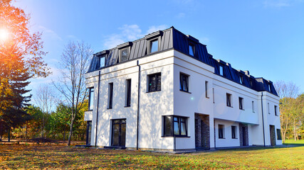 Harmony with nature, eco architecture. Terraced single family homes in newly developed housing estate. The real estate market in the suburbs with lush greenery surrounding. 