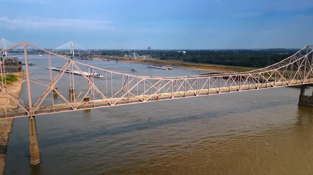 View on the Martin Luther King Bridge over the Mississippi River in St. Louis, Missouri, USA. Diverse boats are on the waterscape. The Clark Bridge at backdrop. Aerial view.
