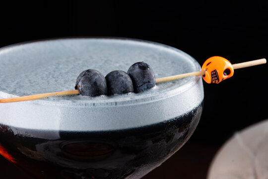close up of blueberries in halloween themed morticia adams cocktail