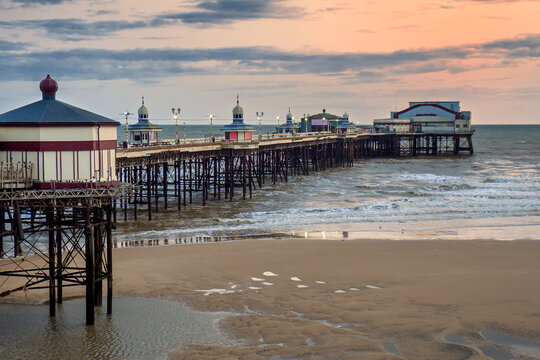 Blackpool North pier just after sunset with a beautiful pink cloudy sky reflected on the sea