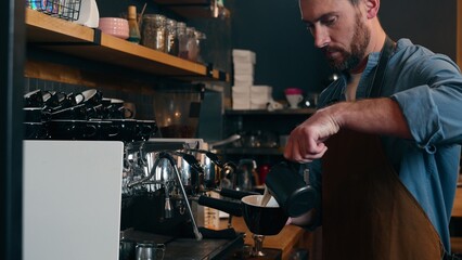 Professional Caucasian employer bartender man preparing order in cafe shop male barista guy pouring milk cream into cup latte cafeteria small business owner working catering waiter making coffee drink