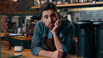 Disappointed Caucasian waiter man barista boredom in cafeteria exhausted employer problem bartender...