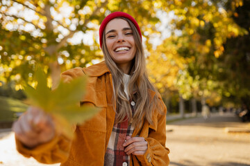 young attractive blond woman walking in autumn park, stylish , smiling