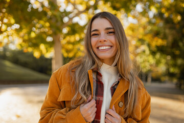young beautiful blond woman walking in autumn park, stylish , smiling, happy, trendy season warm outfit, wearing velvet terracotta color jacket