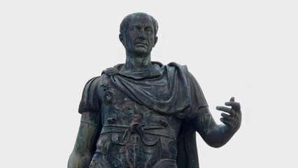 Rome, Italy - 13 January 2025. Statue of Julius Caesar in Roman attire stands with a raised arm, detailed armor, and stern expression, captured against a pale sky.