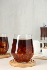 Tasty iced coffee on white table. Space for text