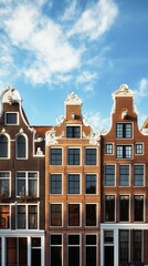 Fototapeta premium Colorful Historic Buildings Line a Street in Amsterdam Under a Bright Blue Sky