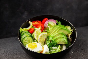 Avocado salad egg, tomato, onion, green leaf salad vegetable dish natural tasty snack fresh gourmet food background on the table rustic top view copy space keto and paleo diet vegan and vegan food