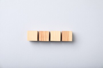 Wooden cubes on light background, top view