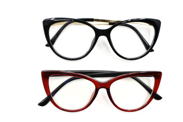 Two pairs of women's glasses with red and black cate yee shape frames isolated on a plain white background. Vision and eyesight concept,