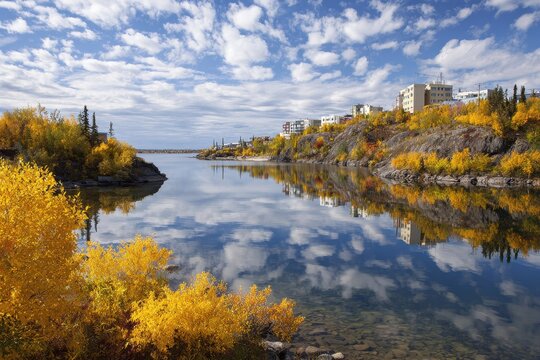 Yellowknife Serenity: A Beautiful Daytime Landscape of Tundra, Calm Lake, and Lush Foliage Amidst Peaceful Canadian Skies